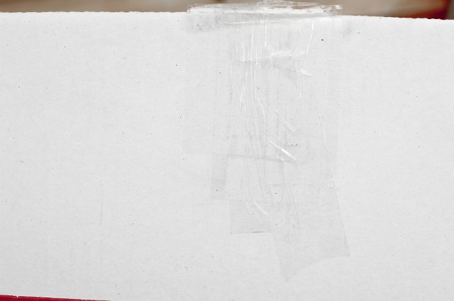 Transparent packaging tape on the lid of a white cardboard box in a close up background view with copy space