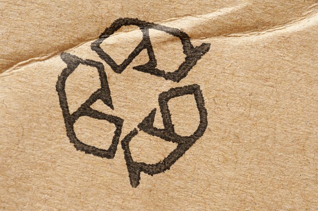 Recycle icon stamped on brown cardboard packaging to be reused to save pollution in the environment