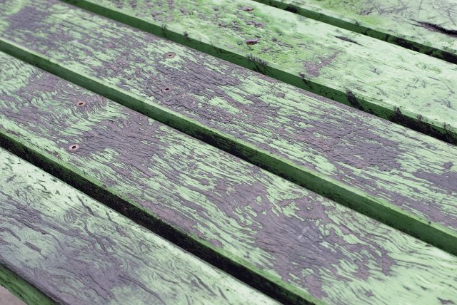 Old worn weathered wooden decking background texture with flaking paint in a diagonal view