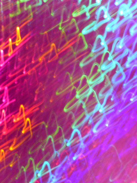 a grainy background with abstract light trails in rainbow colours