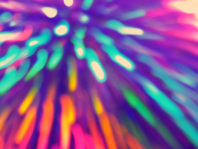 blurred colorful trails of light emanating from the upper left of the image create a bold multi-coloured backdrop
