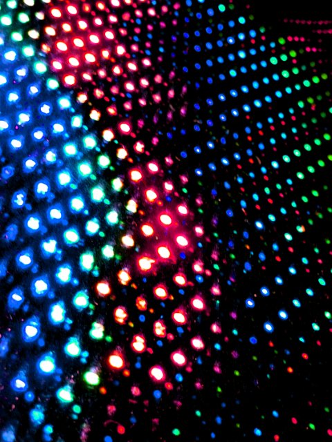 angled background on black with varying intensities of colored light points