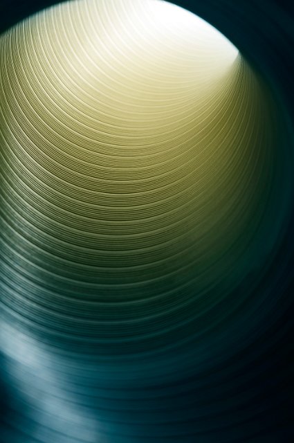 yellow light glowing at the end of a silver metal pipe or tube