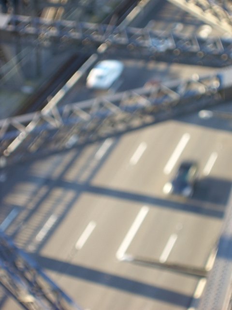 out of focus image of a bridge, cars and support girders