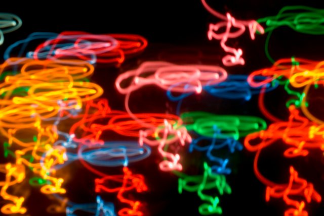 a squiggly background of coloured lines traced on black