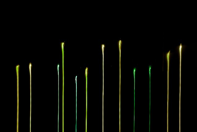 lights with trails falling to the bottom of the frame in various green tones