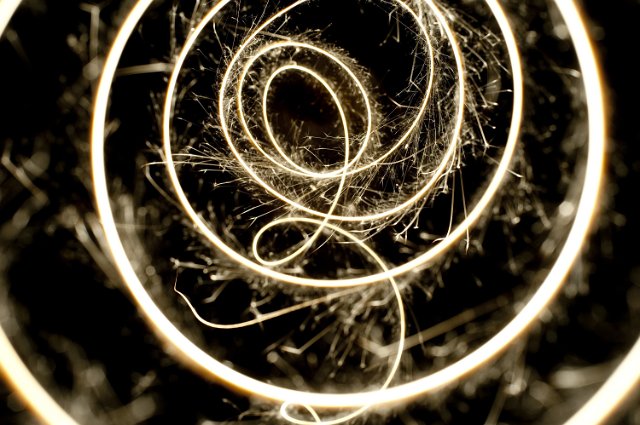 a bright line of sparks plotting a looping curved pattern