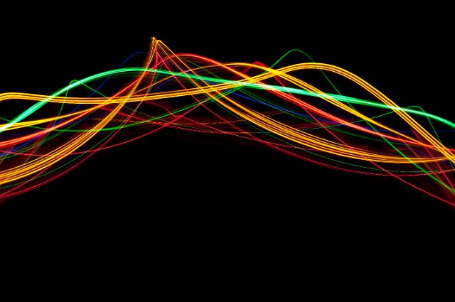 vividly colored waves of light against a black backdrop