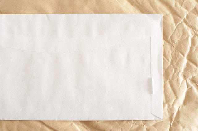 close up image of an envelope with space for text surrounded with crumpled paper