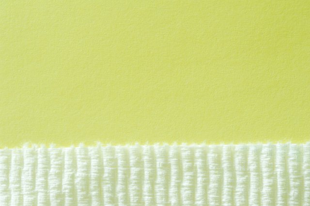 a rough paper surface forms a border for a textured green border