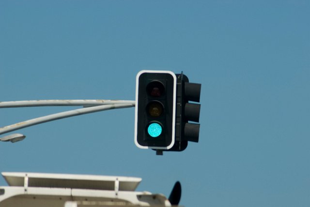 green traffic light suspended above the road at an intersection