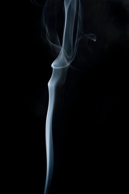 an organically twisting and bending line of smoke