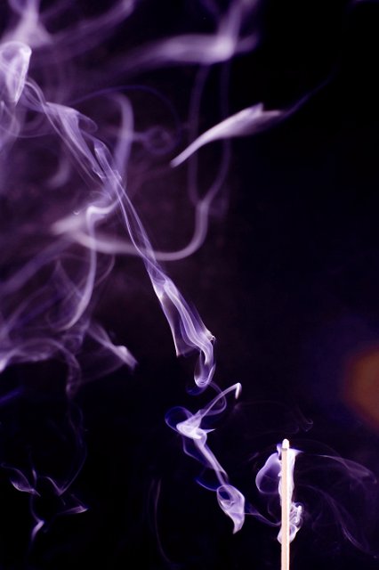 vortices of smoke rising from a burning incense stick