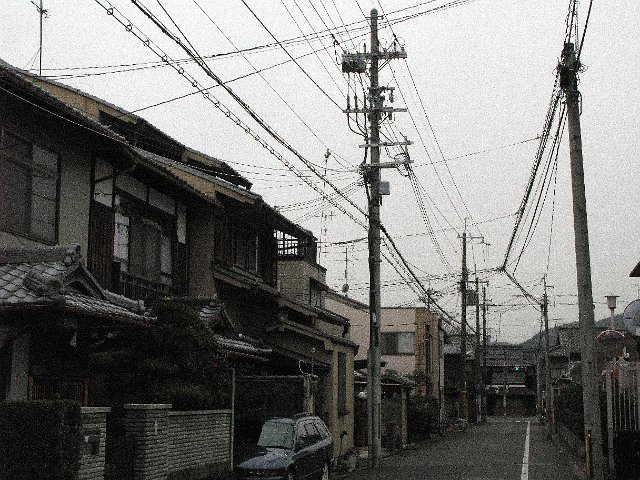 grainy image of power cables strung across a street in japan