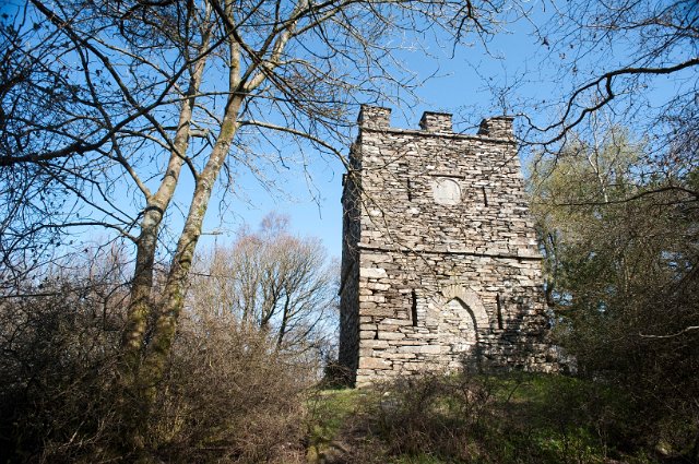 Square stone folly with crenellations in the forest, a building built for whimsical reasons or as a conversation piece during Victorian times