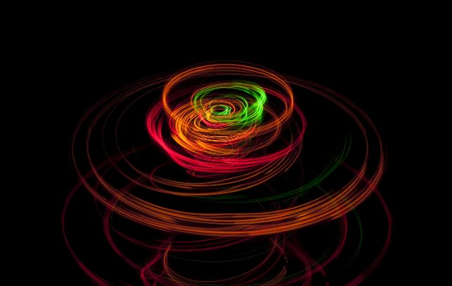 a long exposue image of colorful lights tracing a circular movement pattern