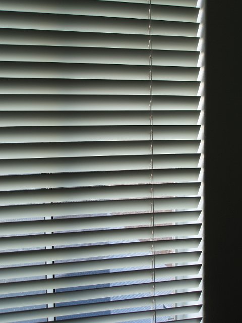 horizontal metal blinds and wall background low key