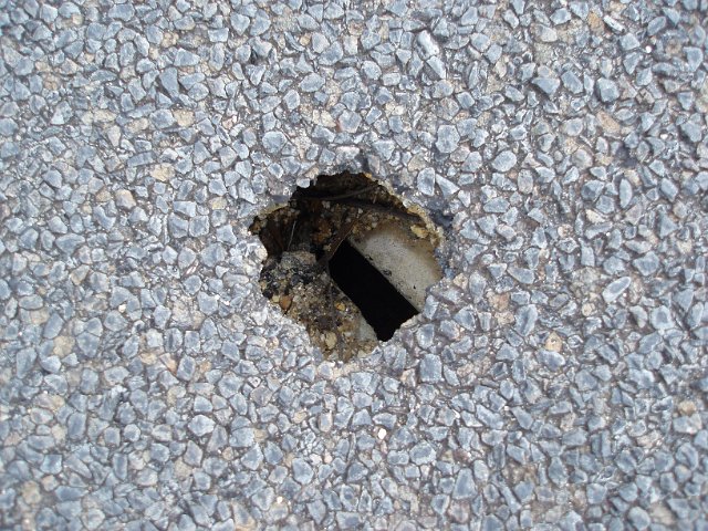 a small hole in a tarmac road