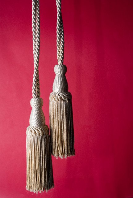 old fashioned ostentatious curtain pulls on a red background