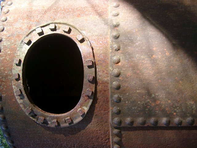 oval port in an old rusted steam engine boiler