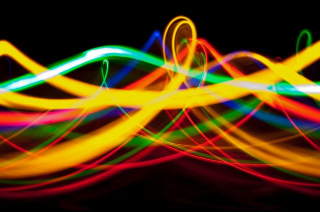 a vibrant corkscrew of colourful light trails on black background
