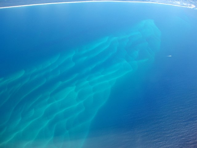 cyan wave patterns on a coastal shallow sandbars
